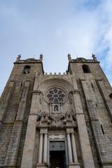 Fototapeta na wymiar Entrada principal de la catedral de Burgos con los campanarios a los lados y su gran vidriera en el centro bajo un cielo nublado.