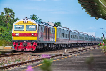 Fototapeta premium Passenger train by diesel locomotive at the railway station.