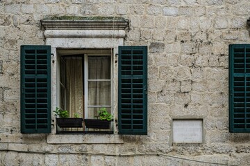 Fototapeta na wymiar Closeup view of a window on a brick wall building in Montenegro