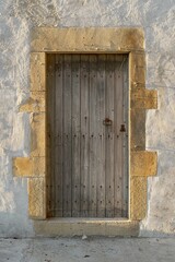 Vertical shot of an entrance to the old stone building through the wooden door