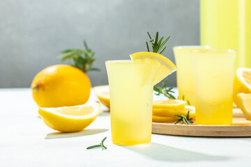 homemade lemon liqueur limoncello with rosemary and lemons on a light background. place for text