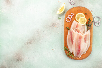 Fresh fish tilapia fillet on a cutting board. Detox and healthy superfoods concept. place for text, top view