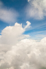 Fluffy clouds. Beautiful dramatic sunset sky above fluffy clouds in early morning from aerial drone view. Traveling by air. View from an airplane window. Aerial view of Malaysia.White clouds floating 