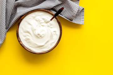 White sauce sour cream or yogurt in wooden bowl, top view