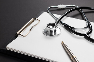A stethoscope with white paper on it, set against a dark background