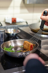 man chef cooking fried tuna fish and green bean in frying pan on kitchen