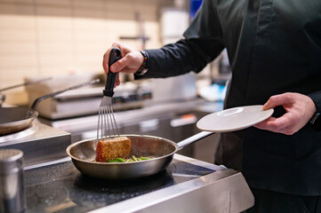 man chef cooking fried tuna fish and green bean in frying pan on kitchen