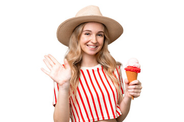 Young English woman with a cornet ice cream over isolated background saluting with hand with happy...
