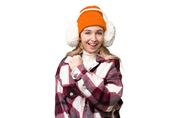 Young  English woman wearing winter muffs over isolated background celebrating a victory