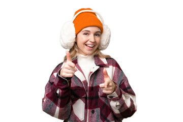 Young  English woman wearing winter muffs over isolated background pointing to the front and smiling