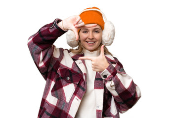 Young  English woman wearing winter muffs over isolated background focusing face. Framing symbol