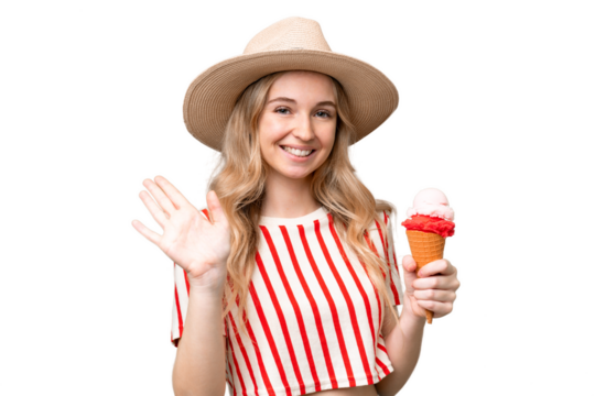 Young English woman with a cornet ice cream over isolated background saluting with hand with happy expression