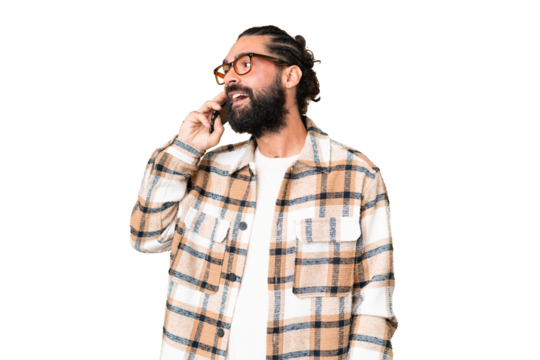Young man with beard over isolated chroma key background keeping a conversation with the mobile phone with someone