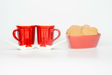 Coffee in red ceramic mugs with heart shaped gingerbread cookies. Gift for valentines day
