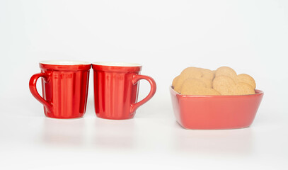 Coffee in red ceramic mugs with heart shaped gingerbread cookies. Gift for valentines day