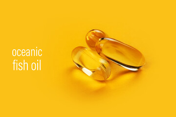 Three capsules Omega 3 on yellow background. Health care concept