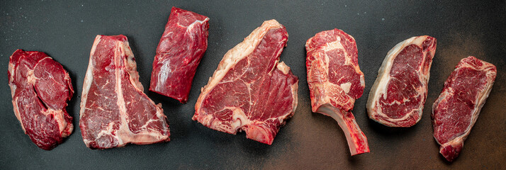 Black angus prime meat set for grilling with fresh herbs, spices. Long banner format. top view