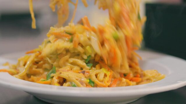 Putting cheese kottu on a plate. Local Sri Lankan food. Close up.