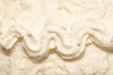 Cake cream texture, sweet whipped cream. Background of yogurt close-up with a pattern.