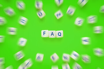 FAQ - frequently asked questions as text on wooden cubed with movemend effect of other cubes with...