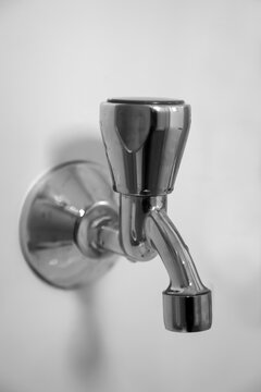 Nahaufnahme eines Wasserhahn an einer wei&szlig;en Wand.