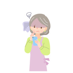 スマホの画面を見て不安な顔をするエプロン姿の中年女性