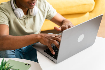 Cheerful black man working on laptop