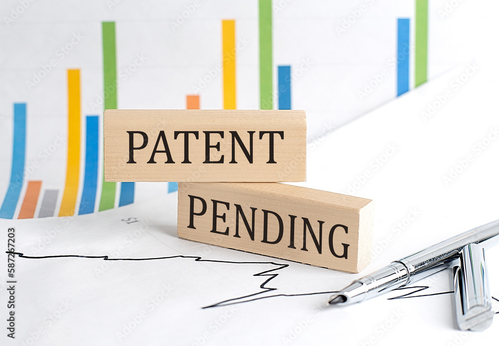 Poster patent pending text on a wooden block on chart background , business concept