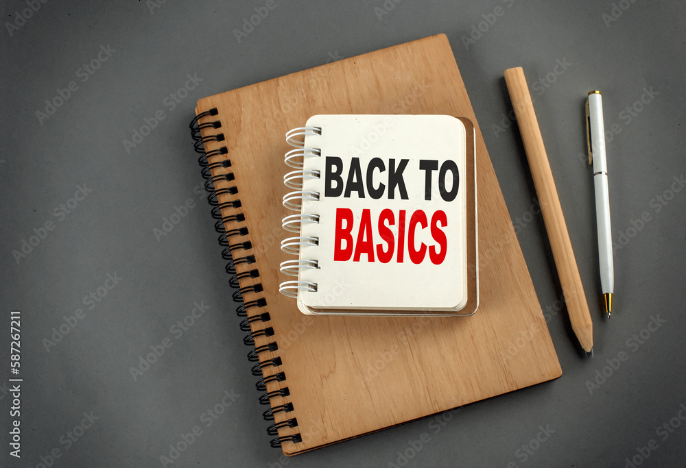 Poster back to basics text on notebook with pen and pencil on grey background