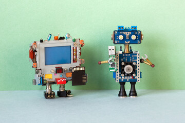 The robot with usb drive and retro computer with memory card. The concept of sharing and storing information using compact memory tools - 587267241