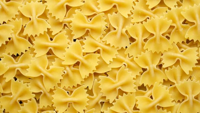 Uncooked Italian pasta farfalle top view, rotation