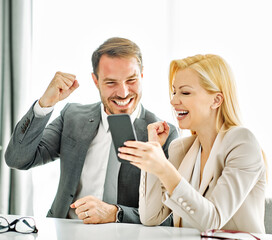 young business people businessman businesswoman smartphone celebrating success mobile phone smartphone social