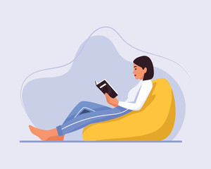  a girl with short hair sits on a chair (ottoman) with a book