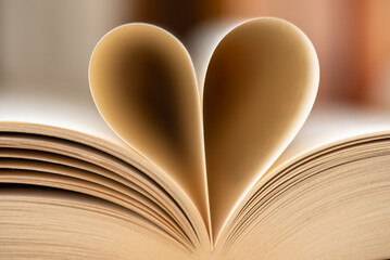 Vergilbte Buchseiten zu einem Herz geformt.