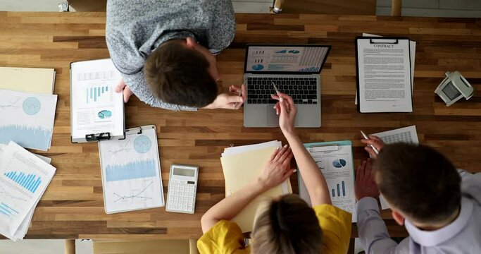 Collaboration and discussion of financial and commercial indicators documents and laptop top view. Business team communicating commercial indicators