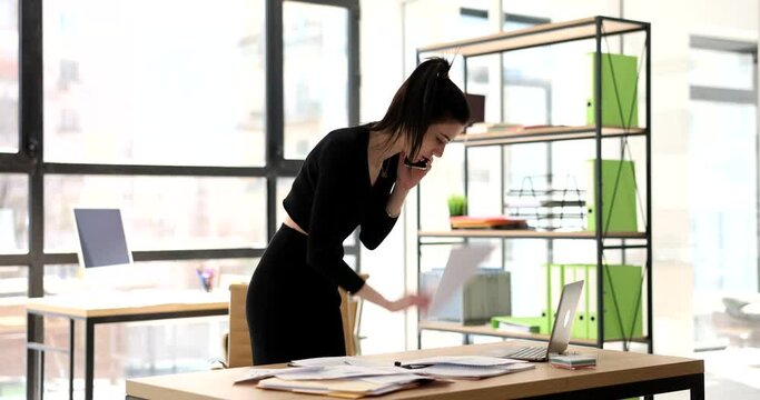 Stressed business woman talking on phone with dissatisfied customer and solving problems remotely. Manager listens to work related complaints and is outraged by financial report