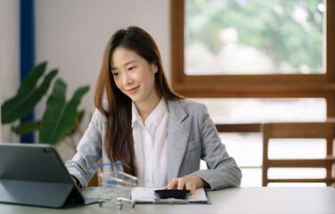 Female businessman working with calculator, business document and laptop computer notebook at home office.