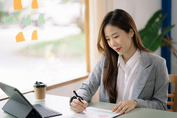 Female writes information businessman working on laptop computer writing business plan while sitting in home office.