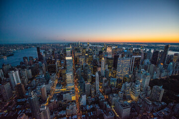 elevated sunset view over New York city with illuminated buildings
