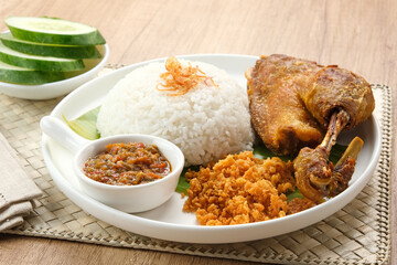 Bebek Goreng Kremes, served with chili sauce (sambal) and cucumber. Indonesian food
