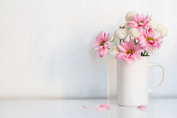white and pink  chrysanthemums in vintage cup on white background