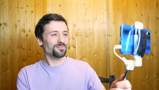 Man taking selfie with smartphone, using self stick