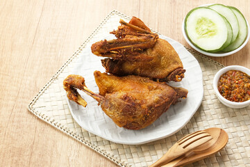 Bebek Goreng, served with chili sauce (sambal) and cucumber. Indonesian food
