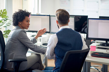 Two young coworkers discussing together