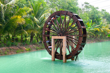 Native,water turbine made of wood.Wooden Water Wheel for rice irrigation in Thailand.Asian village culture concept. © noon@photo