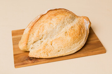 Freshly baked bread on cutting board against white wooden background. perspective view bread with copy space