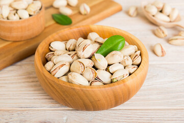 Fresh healthy Pistachios in bowl on colored table background. Top view Healthy eating concept. Super foods