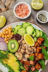 Teriyaki baked tofu with avocado, chickpeas, cucumber and mushrooms. buddha bowl. Vegan lunch salad. Food recipe background. Close up