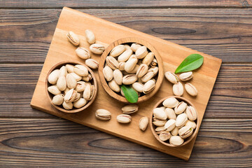 Fresh healthy Pistachios in bowl on colored table background. Top view Healthy eating concept. Super foods
