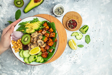 Healthy vegetable lunch in a Buddha bowl with tofu, avocado, chickpeas, cucumber and mushrooms, banner, menu, recipe place for text, top view
